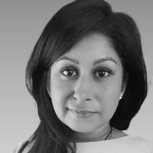 A portrait photo of Sonali Mullick in black and white. She is wearing a white jumper.